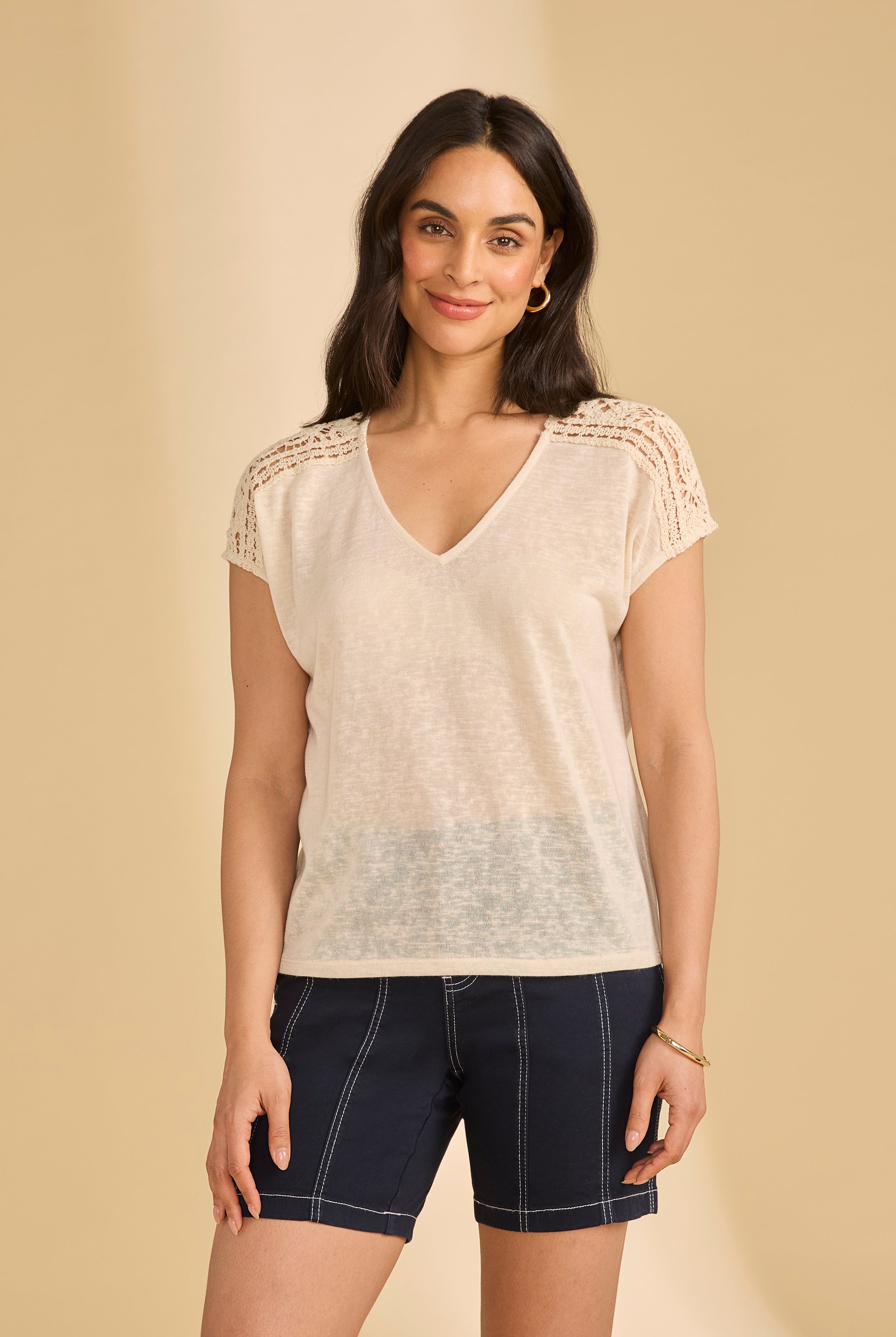 Front view of beige V-neck top with crochet shoulders paired with navy shorts by French Dressing Jeans (FDJ)