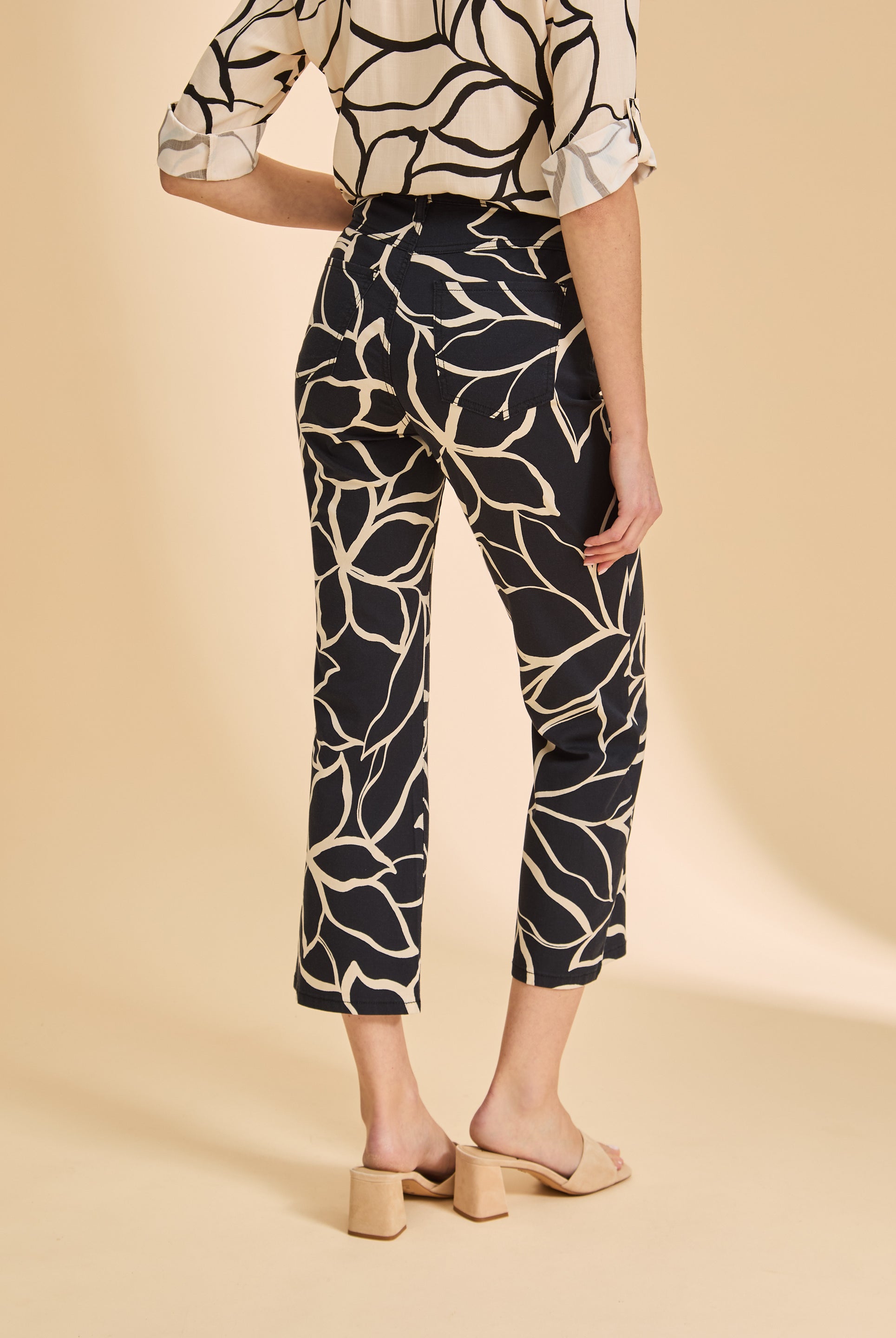 Back view of black plumeria crop pants featuring patch pockets and floral design by French Dressing Jeans (FDJ)