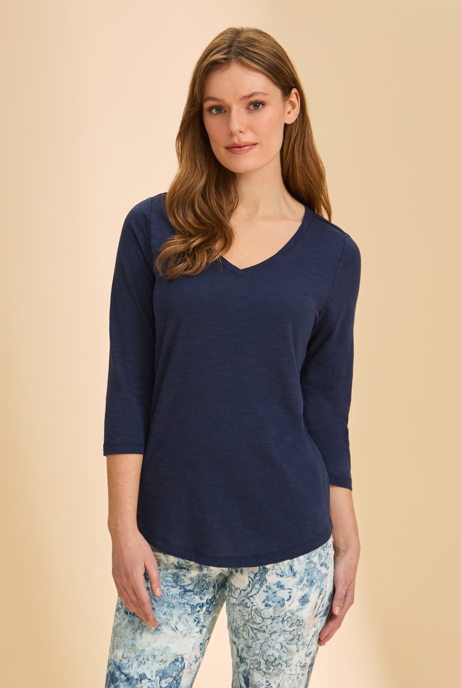 Front view of navy V-neck 3/4 sleeve top with curved hem and patterned pants by French Dressing Jeans (FDJ)