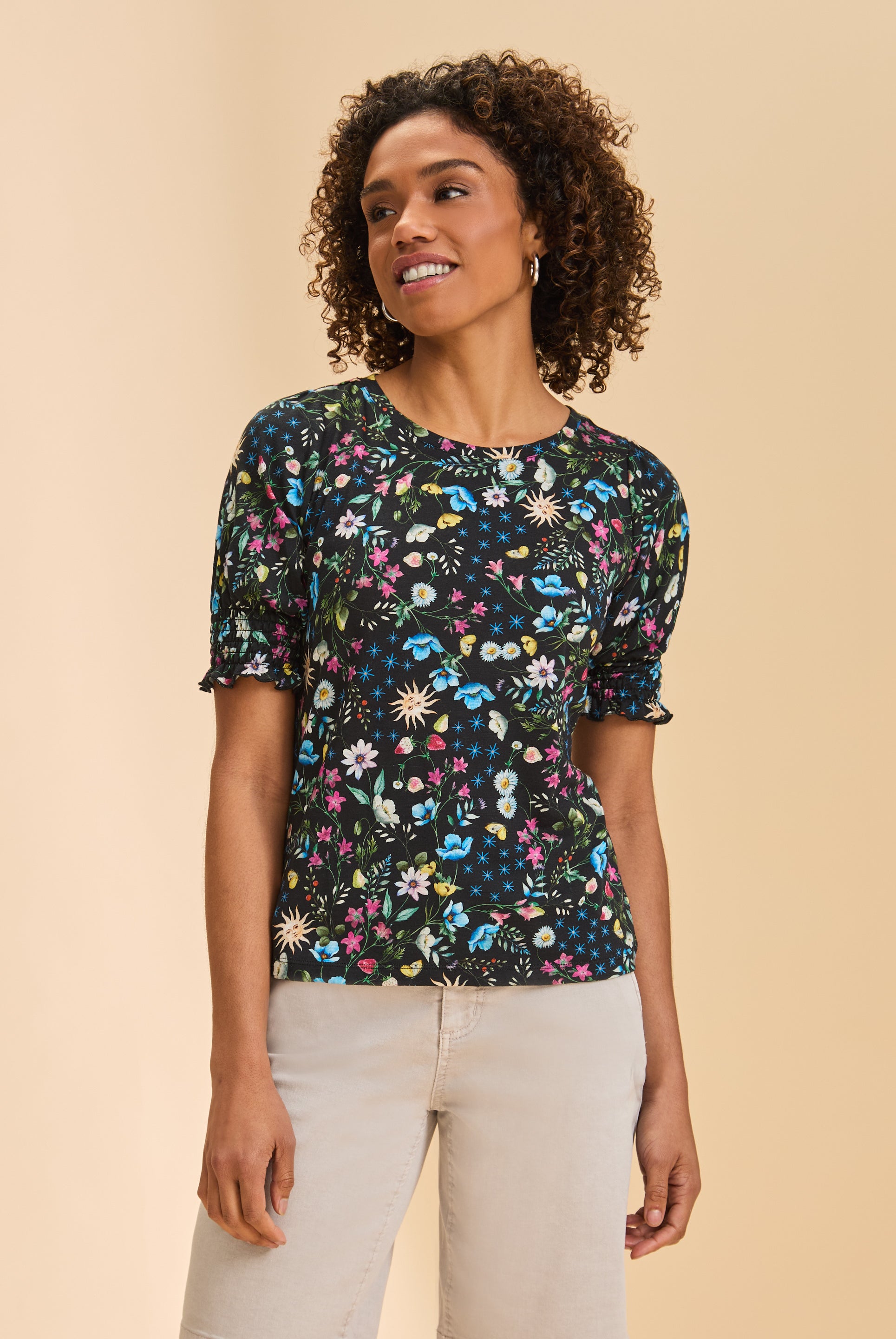 Front view of black floral short sleeve top with smocked sleeves and round neckline by French Dressing Jeans (FDJ)